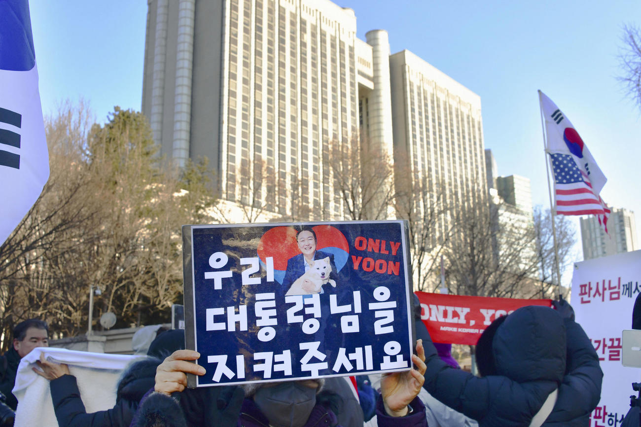 ソウル中央地裁（奥）の前に集まった韓国の前大統領、尹錫悦被告の支持者ら＝13日（共同）
