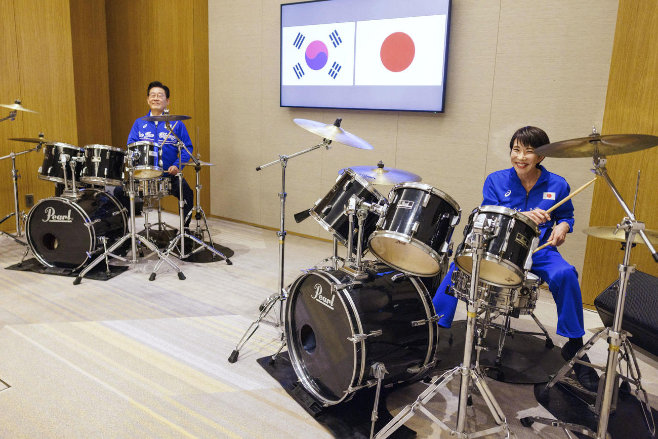 会談後にドラムで「共演」した高市首相（手前）と韓国の李在明大統領（共同）