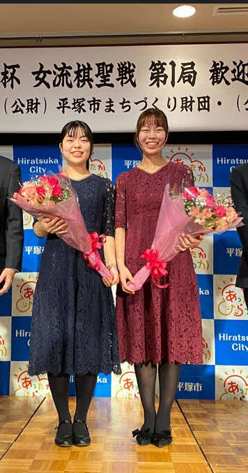 囲碁界41年ぶりに実現する姉妹タイトル戦の前夜祭で花束を手にする妹の上野梨紗女流棋聖（左）と挑戦者で姉の上野愛咲美女流名人（日本棋院提供）