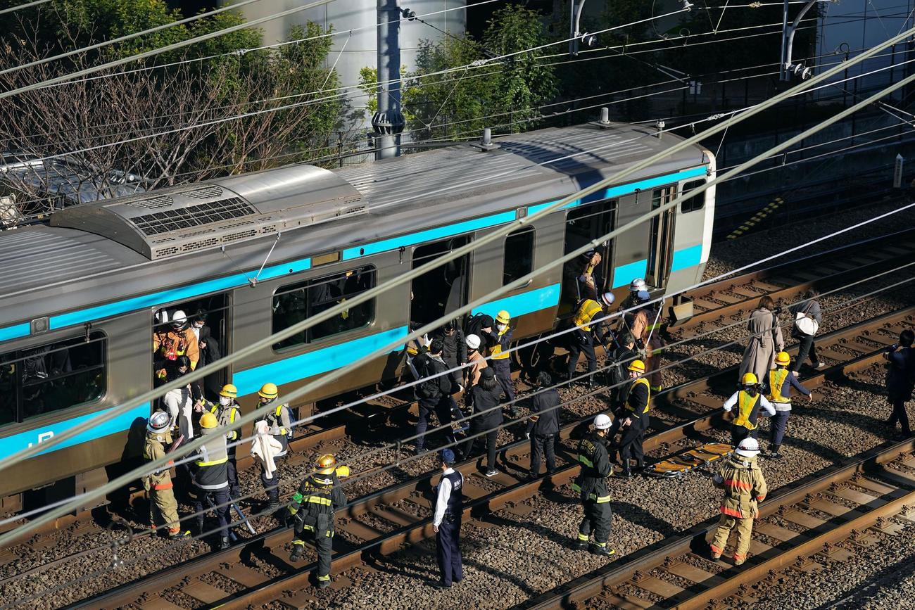 高輪ゲートウェイ－田町間で停車したJR京浜東北線の車両から線路に降りる乗客（共同）