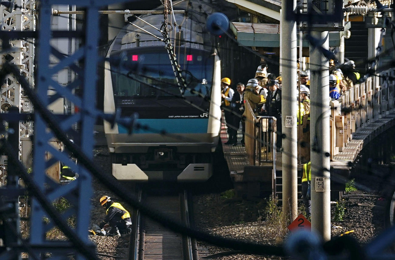 JR田町駅で京浜東北線の車両付近を調べる作業員ら（共同）