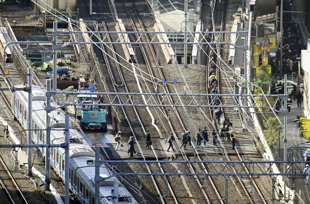 新橋－浜松町間で停車したJR京浜東北線の車両から降りて線路を歩く乗客（共同）