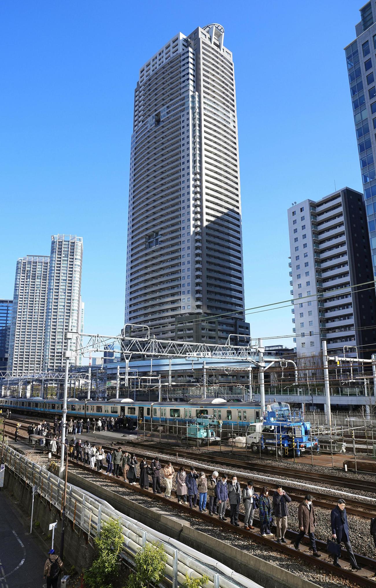 新橋－浜松町間で停車したJR京浜東北線の車両から降りて線路を歩く乗客（共同）
