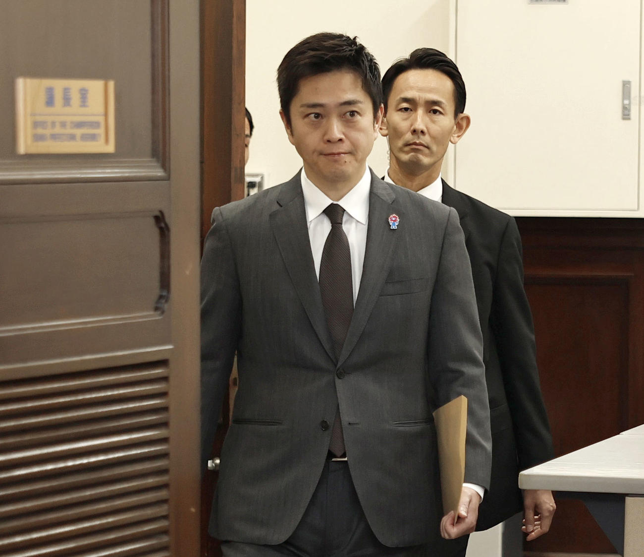 辞職願を手に、大阪府議会の議長室に入る吉村洋文知事（共同）
