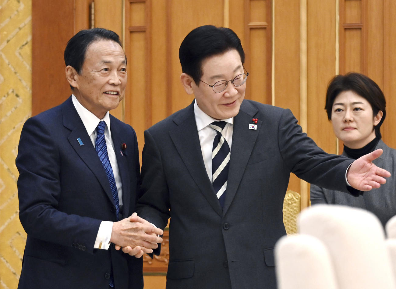 会談前、韓国の李在明大統領（右）と握手を交わす自民党の麻生副総裁＝16日、韓国大統領府（共同）
