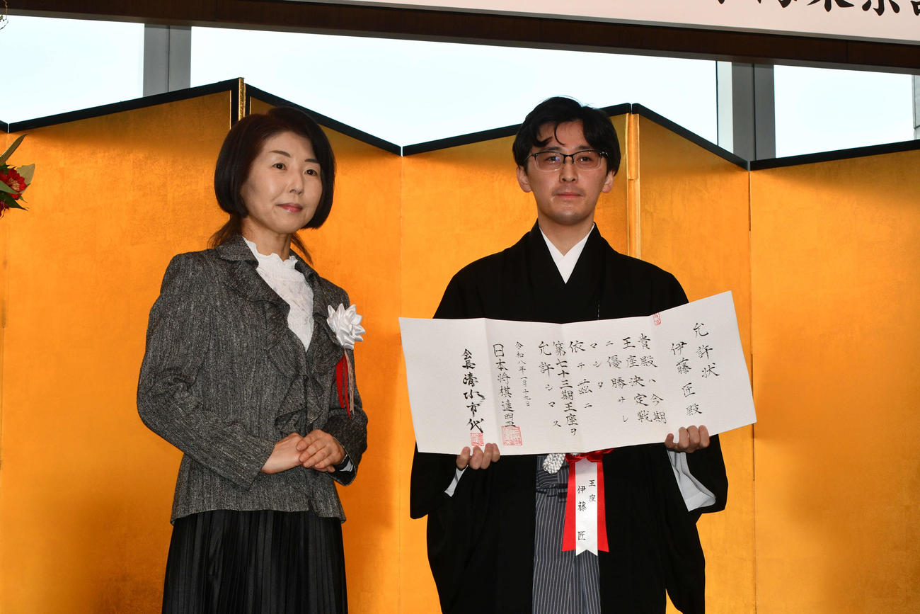 日本将棋連盟の清水市代会長（左）から允許（いんきょ）状を贈られた伊藤匠王座（右）