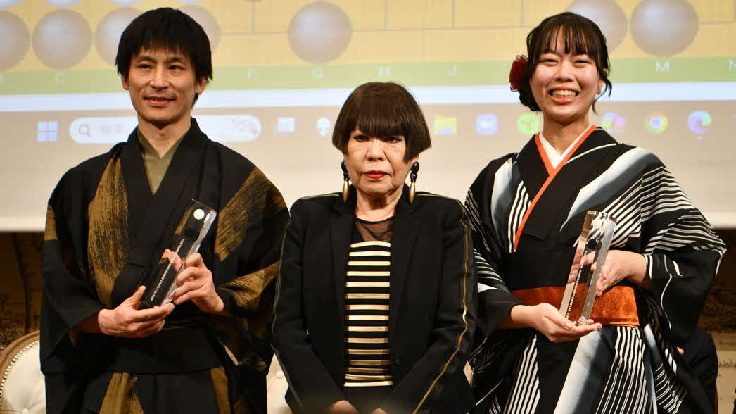優勝した張栩九段（左）と上野愛咲美女流名人（右）にはコシノジュンコ（中）のデザインしたトロフィーが贈られた