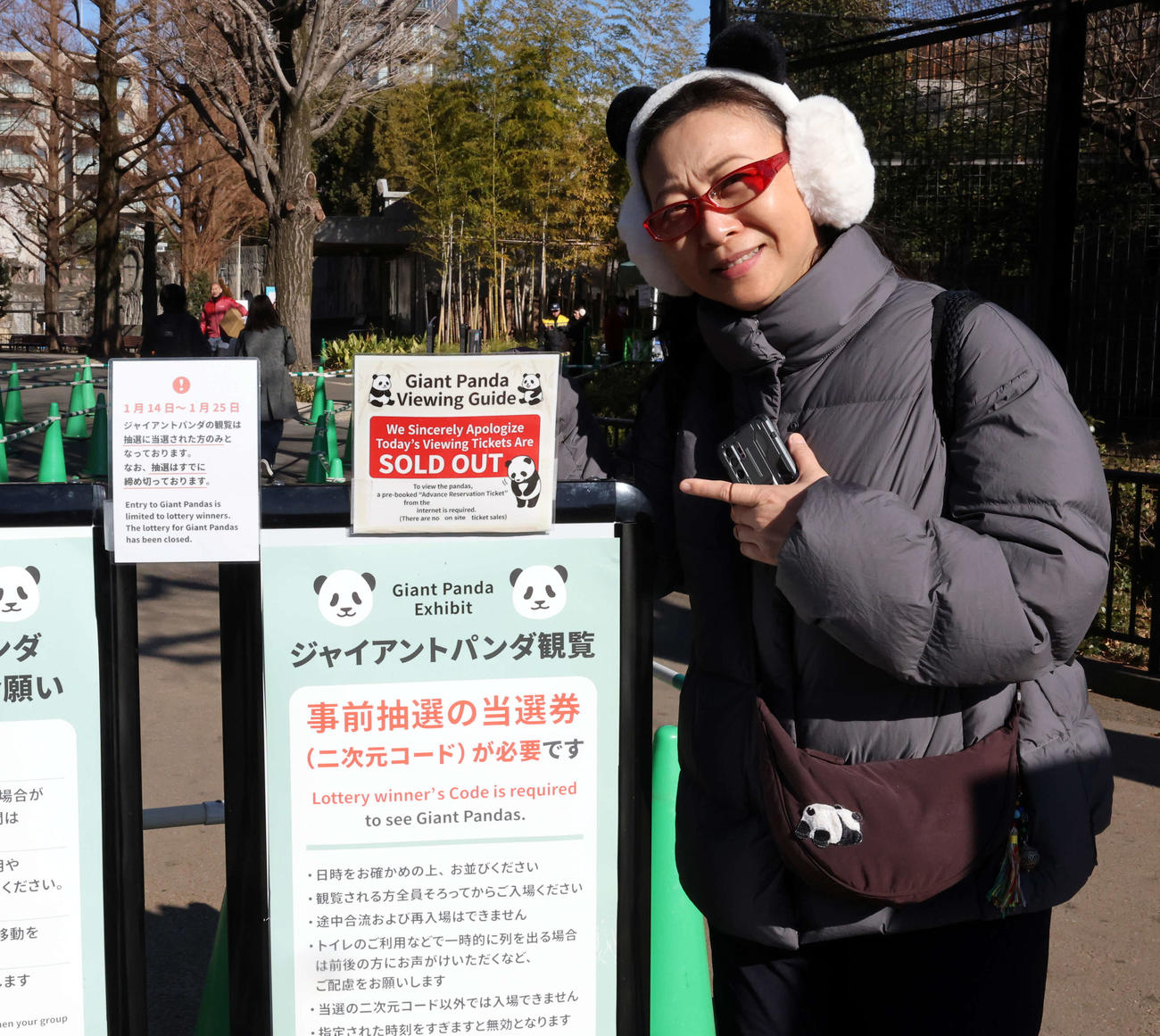 パンダの観覧最終日、パンダのカチューシャを着用して「ソールドアウト」の看板を指さす外国人客（撮影・浅見桂子）