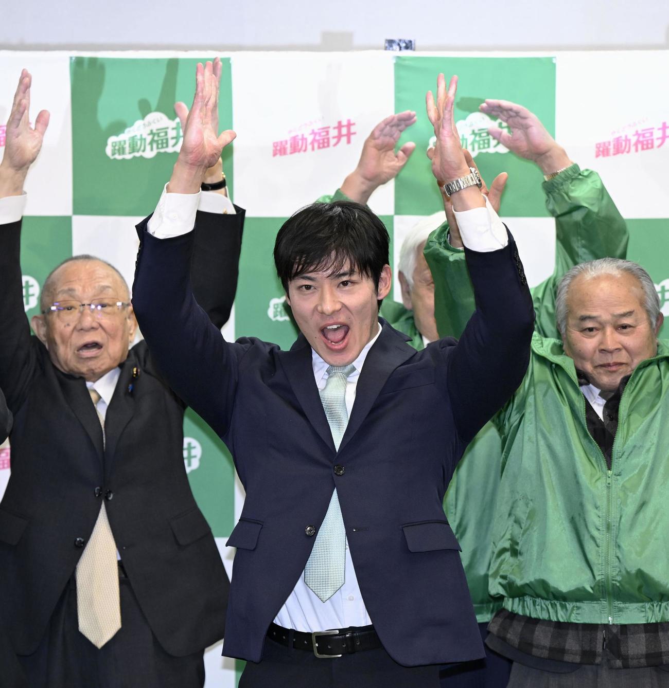 福井県知事選で初当選を決め、万歳する石田嵩人氏＝25日深夜、福井市（共同）