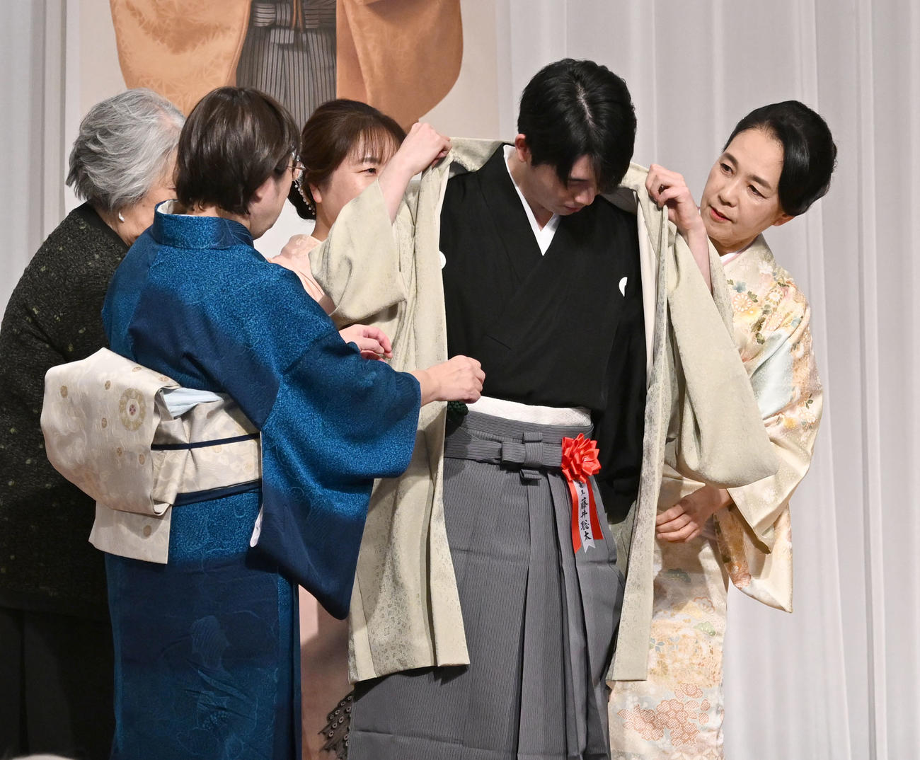 第38期竜王就位式　クラウドファンディングの支援者に贈られた記念の羽織を着せてもらう藤井竜王（撮影・千葉一成）