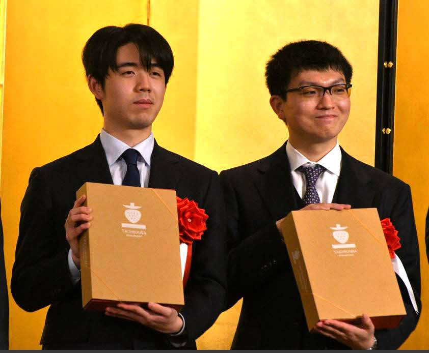立川対局の記念に地元産のブランドいちごを手にする藤井聡太王将（左）と永瀬拓矢九段（右）