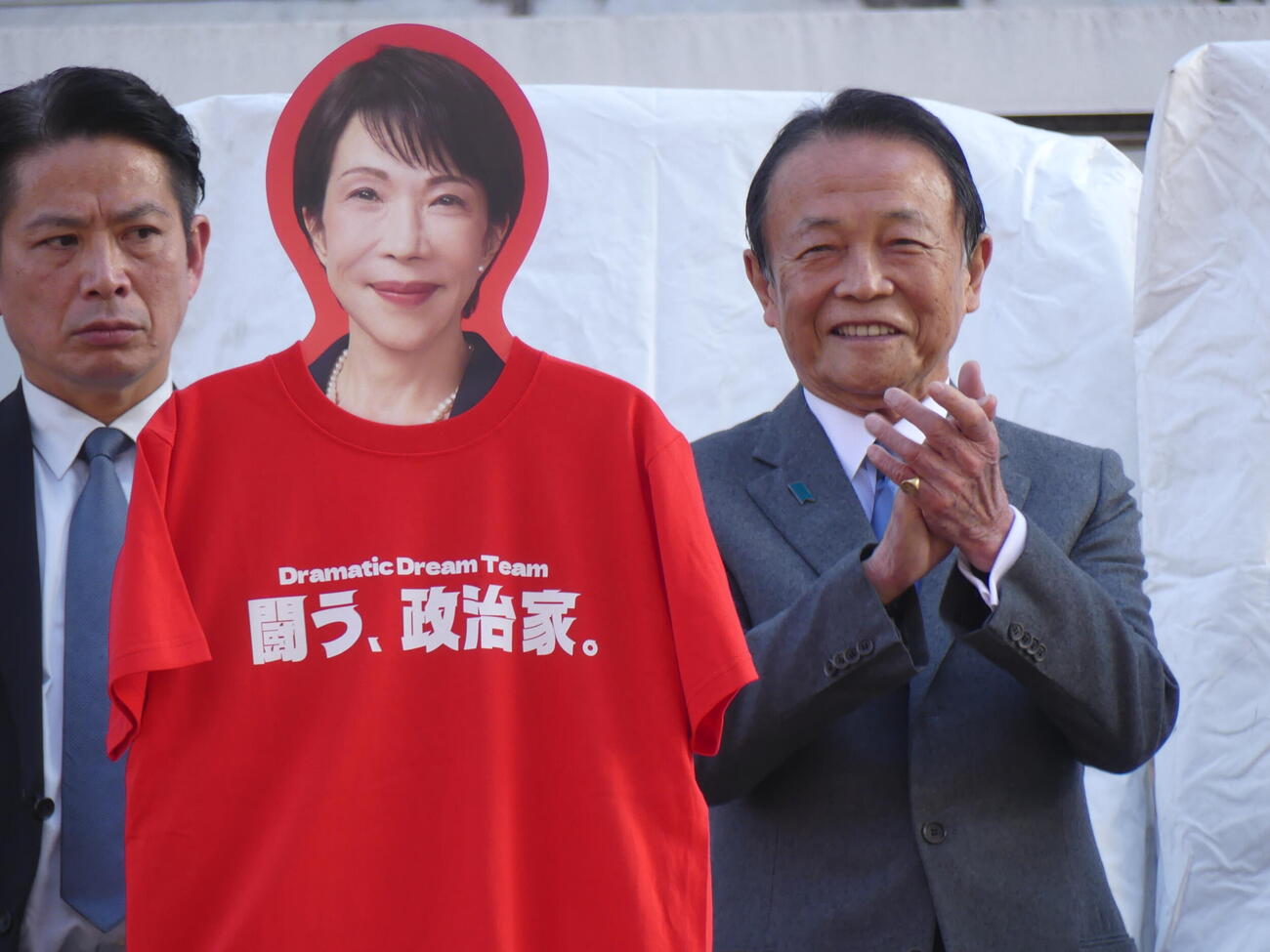 高市早苗首相のボードの横で笑顔をみせる自民党の麻生太郎副総裁（撮影・中山知子）