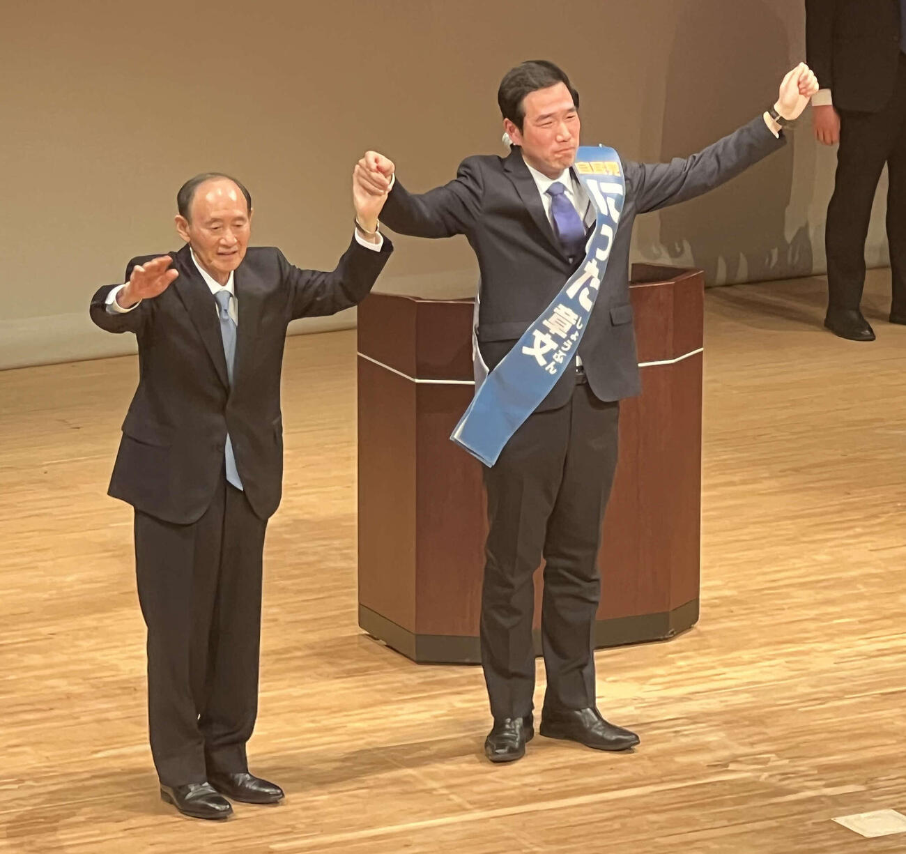 神奈川2区の自民党候補、新田章文氏（右）は、菅義偉氏と決意のあいさつ（26年2月6日撮影）