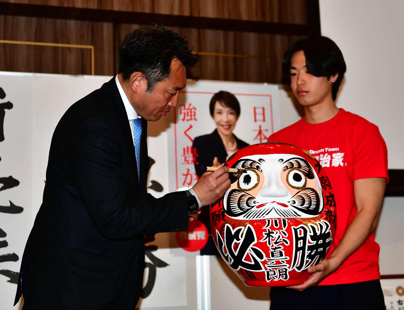 衆院選の東京23区（町田市）で初当選し、だるまに目を入れる川松真一朗氏（左）（撮影・松尾幸之介）