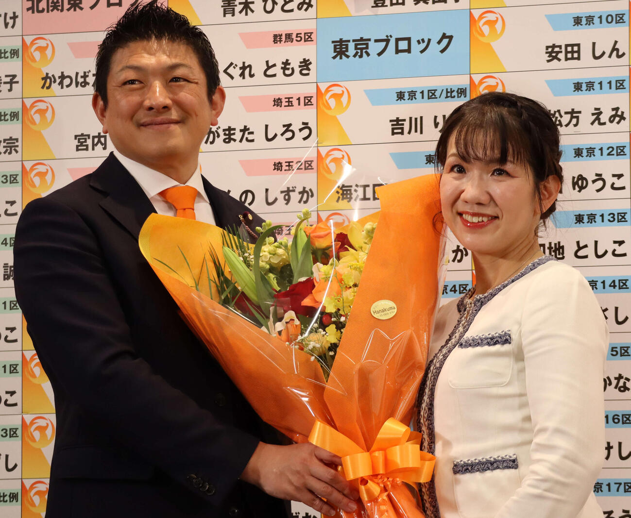 当選確実の豊田真由子氏（右）に花を贈る参政党の神谷宗幣代表