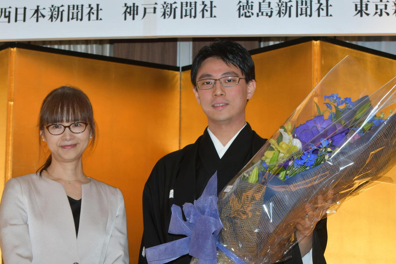 祝辞を述べた吉原由香里六段（左）から贈られた花束を手にする一力遼天元（右）