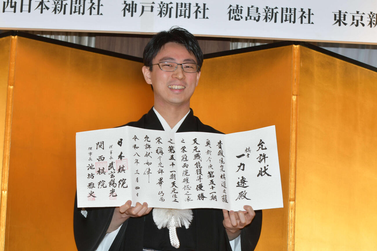 就位式で允許（いんきょ）状を手にする一力遼天元