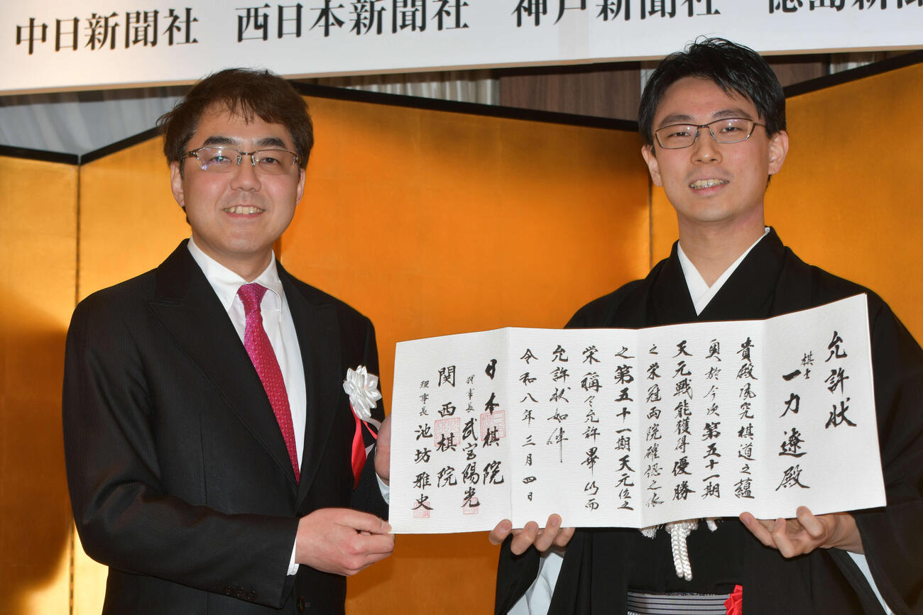就位式で日本棋院の武宮陽光理事長（左）から允許（いんきょ）状を授与された一力遼天元