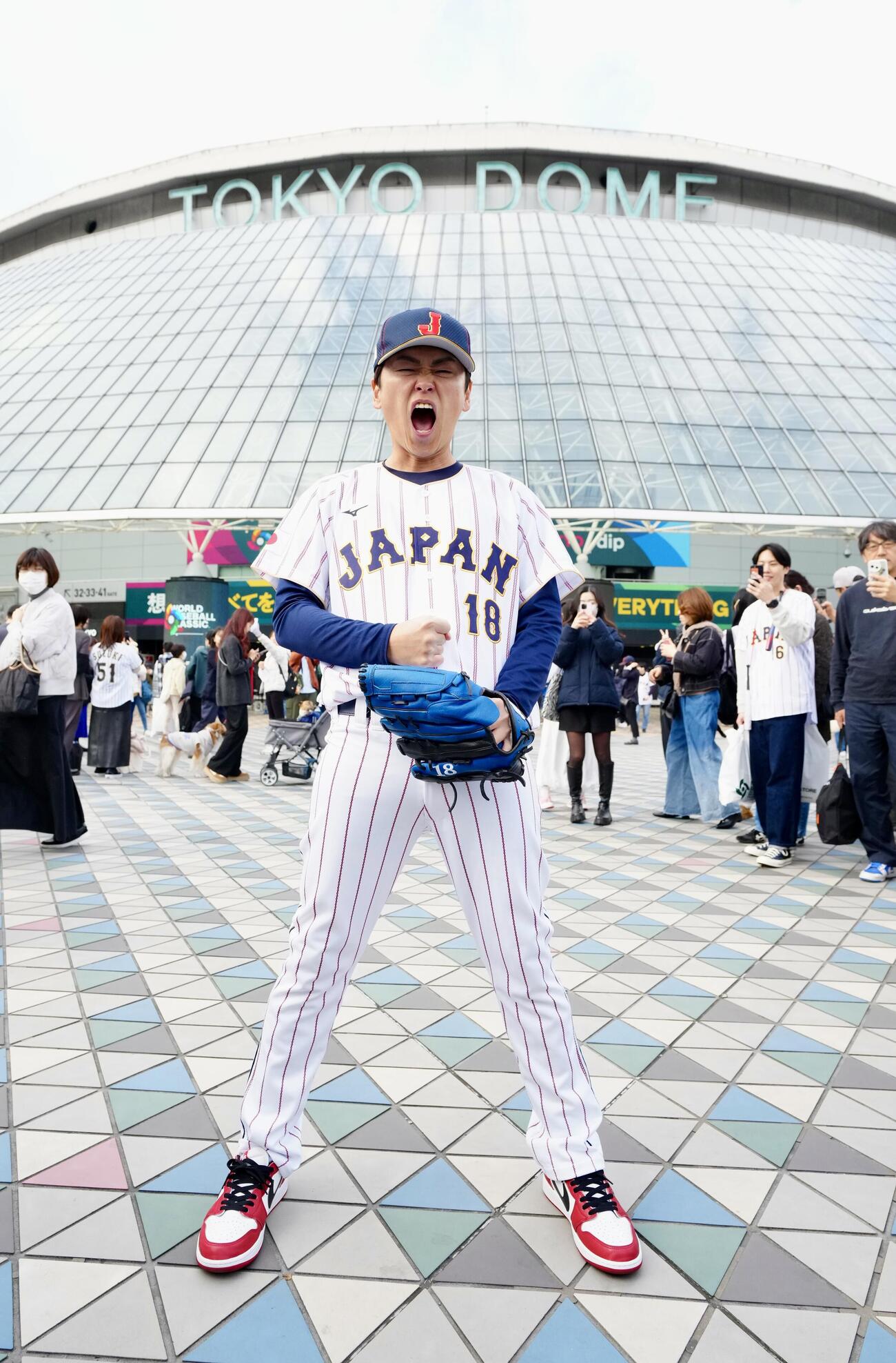 東京ドームを背に気合いを入れる侍ジャパンのドジャース山本由伸をマネる「ちょいまねJAPAN」の山本申伸＝2026年3月6日