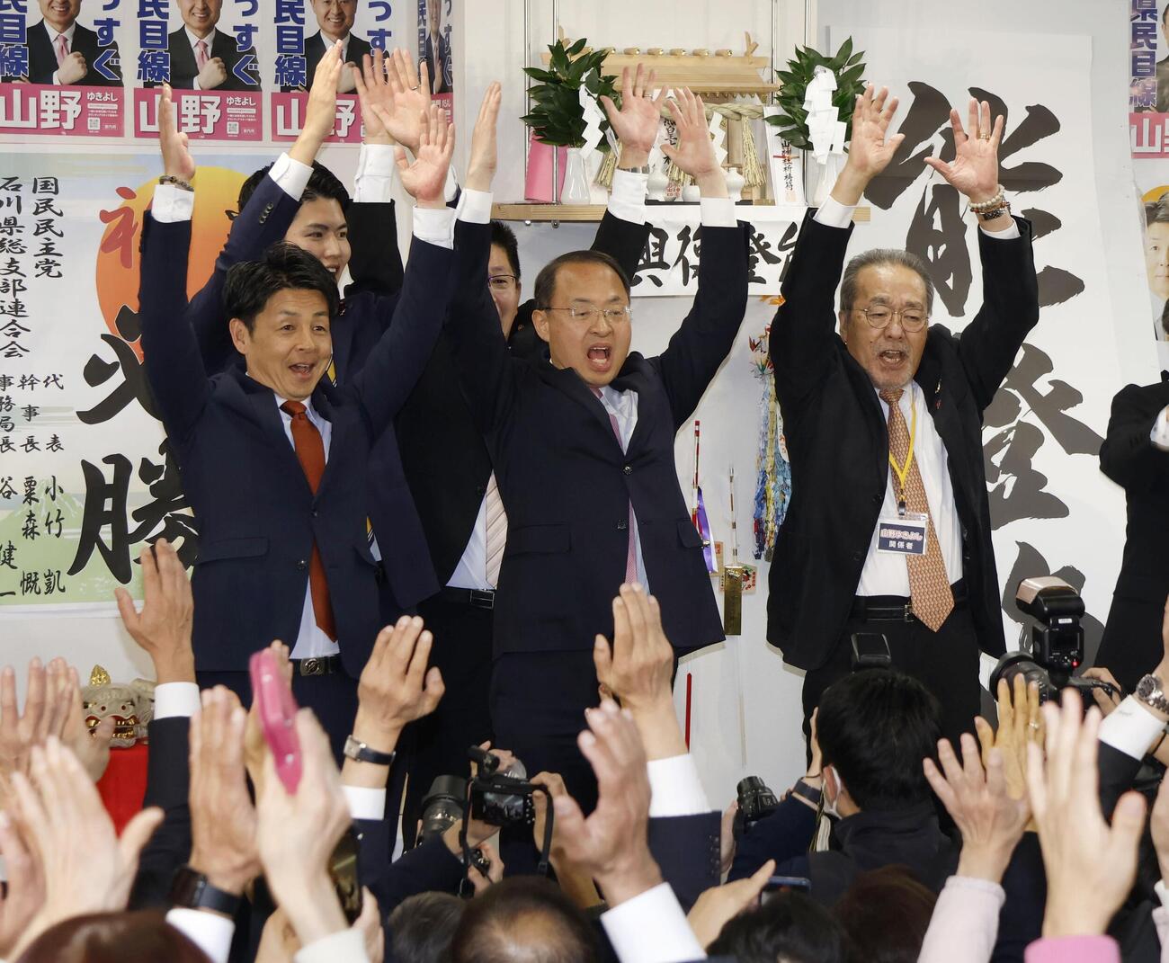 石川県知事選で初当選を決め、万歳する山野之義氏（中央）（共同）