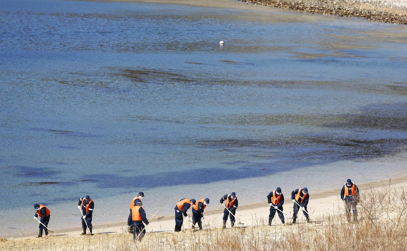 行方不明者の手がかりを求め、岩手県山田町の海岸を捜索する警察官ら（共同）