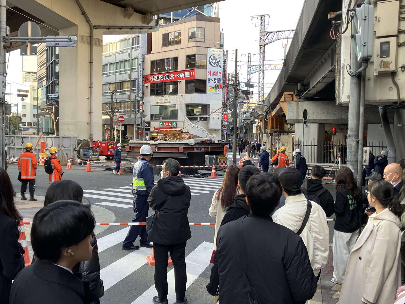 直径約5メートルの管が突き出した現場と見つめる人々（撮影・阪口孝志）