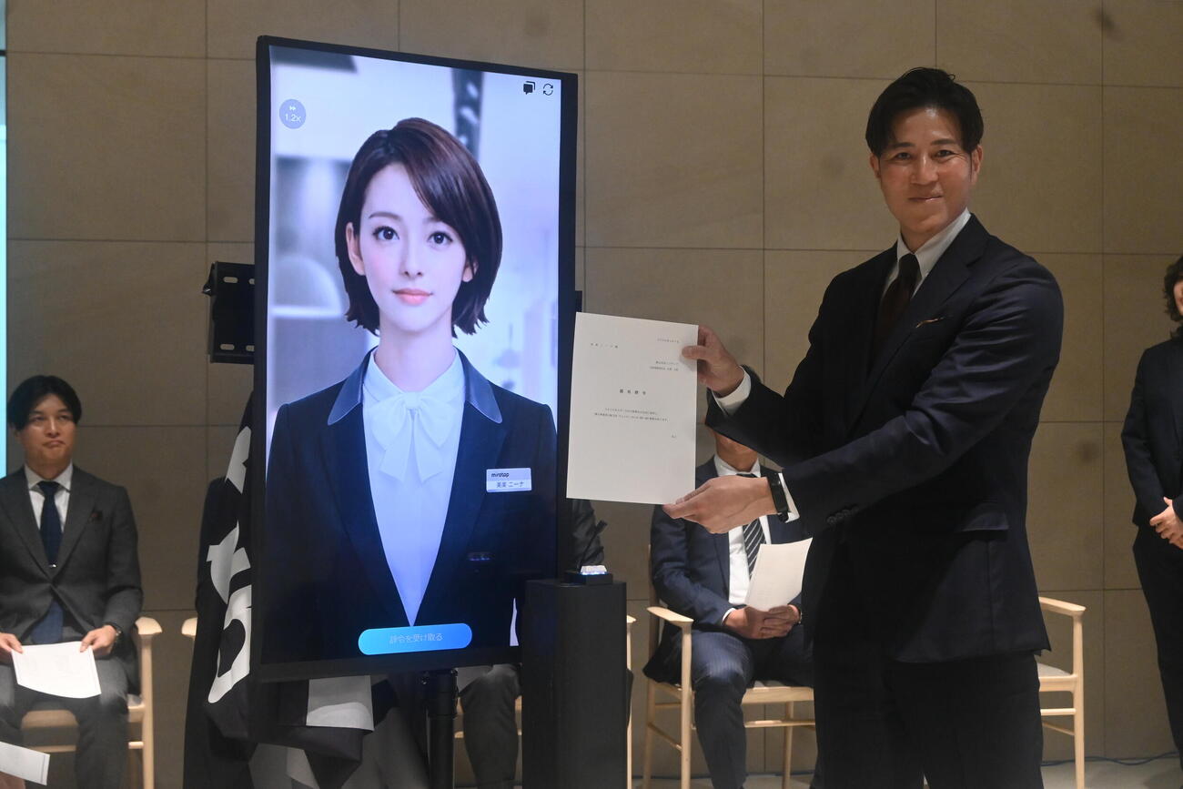 ミラタップ山根太郎社長から辞令を交付されたAI社員「美楽（みら）ニーナ」（撮影・松浦隆司）
