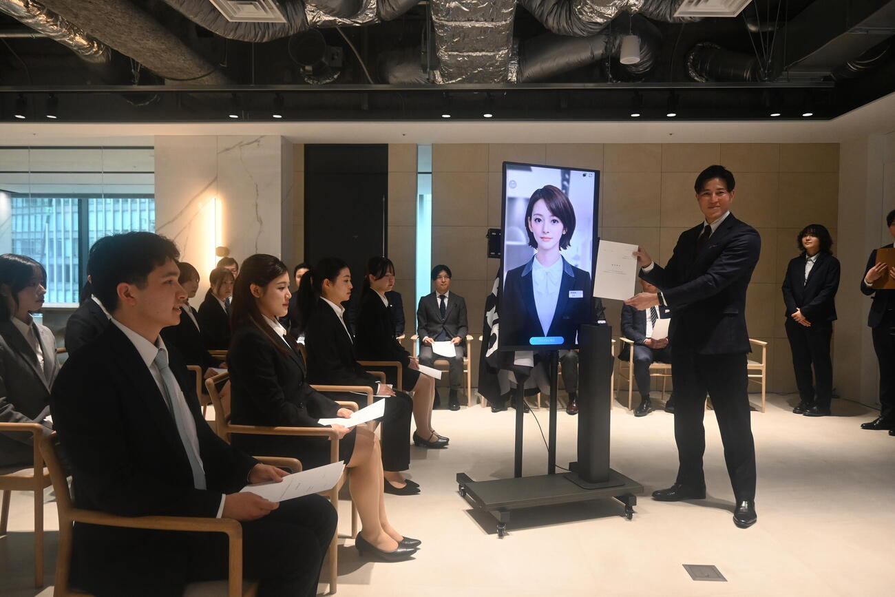ミラタップ山根太郎社長から辞令を交付されたAI社員「美楽（みら）ニーナ」（撮影・松浦隆司）