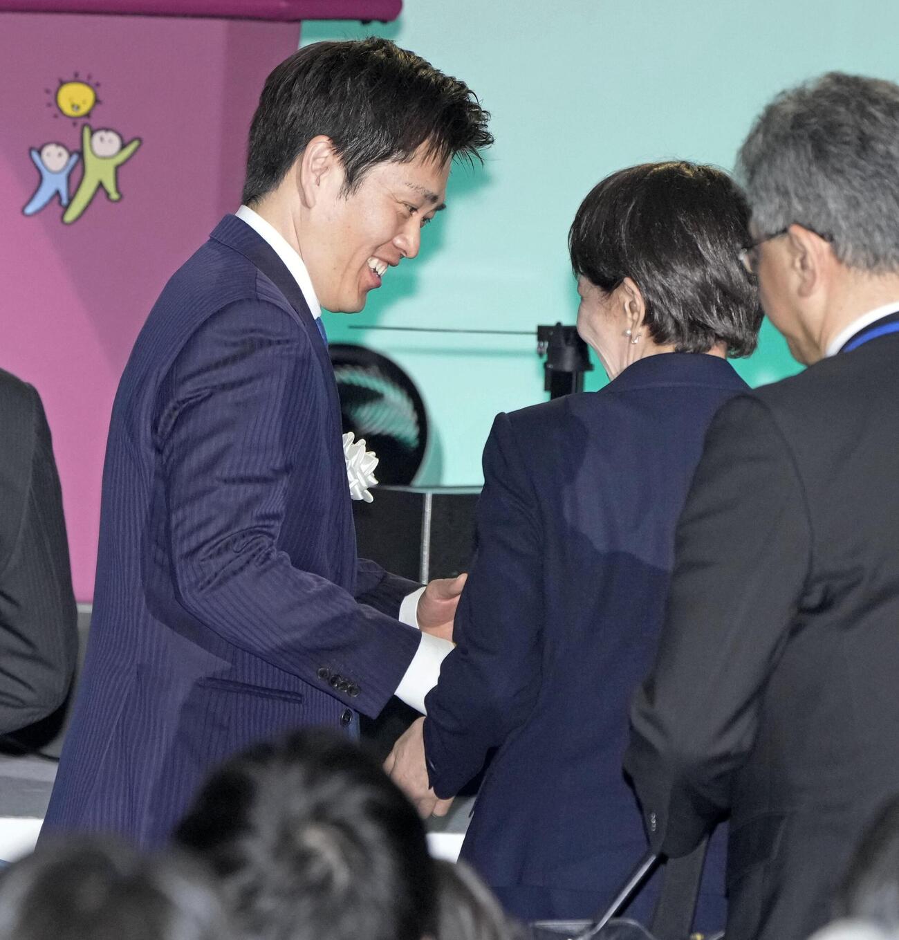 自民党大会の会場を後にする日本維新の会の吉村代表（左）。中央は高市首相（共同）