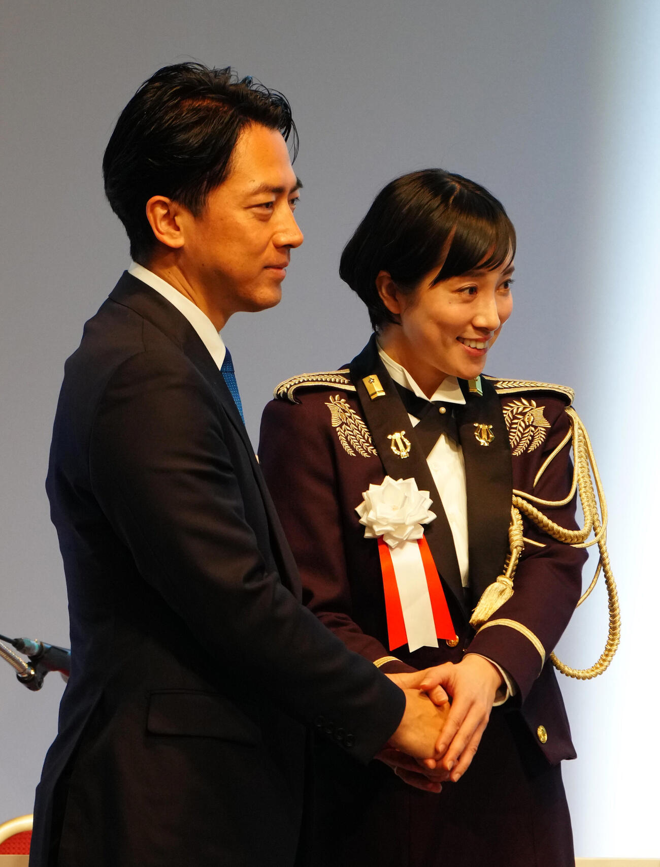 小泉進次郎氏（左）と握手を交わすソプラノ歌手・鶫真衣3等陸曹（2026年4月12日）