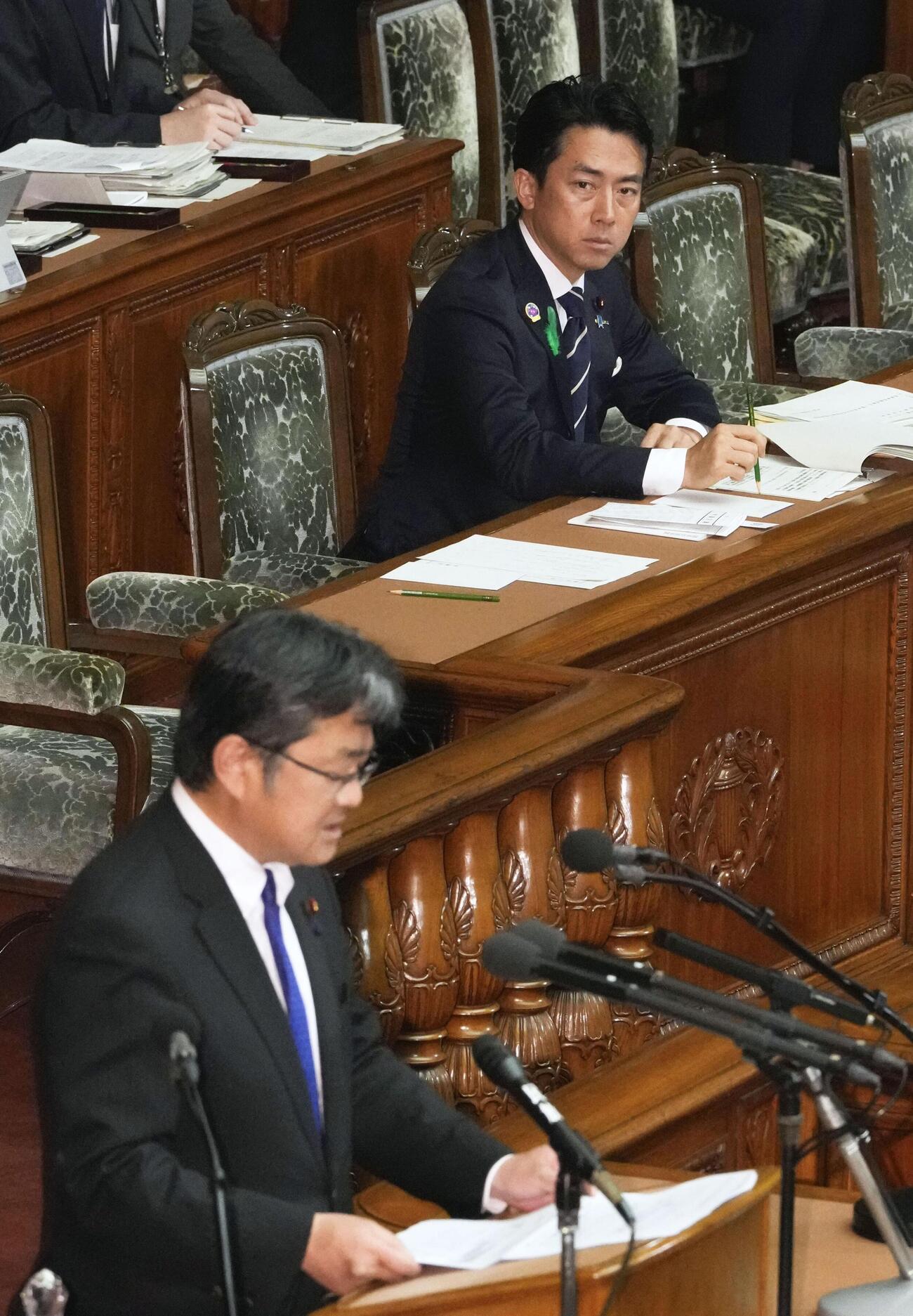 衆院本会議で中道改革連合の吉田宣弘氏（手前）の質問を聞く小泉防衛相（共同）