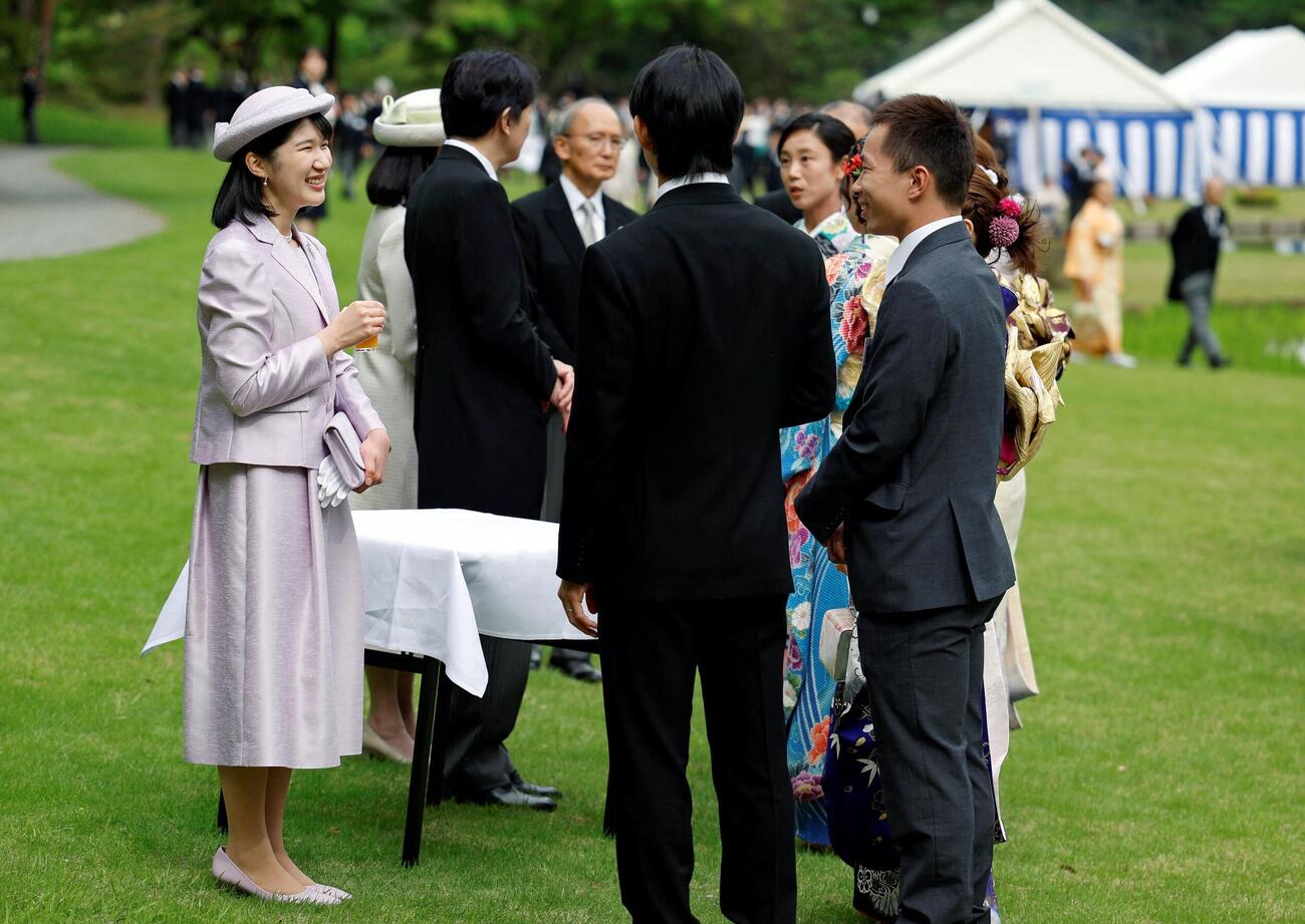 園遊会で薄紫色の衣装をまとい、招待客とご歓談される愛子さま（ロイター）