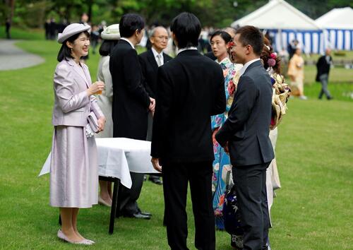 園遊会で薄紫色の衣装をまとい、招待客とご歓談される愛子さま（ロイター）