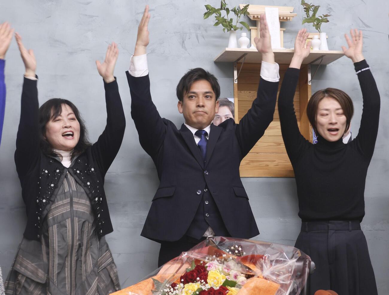 宮崎県小林市長選で初当選を決め、万歳する堀研二郎氏（中央）（共同）