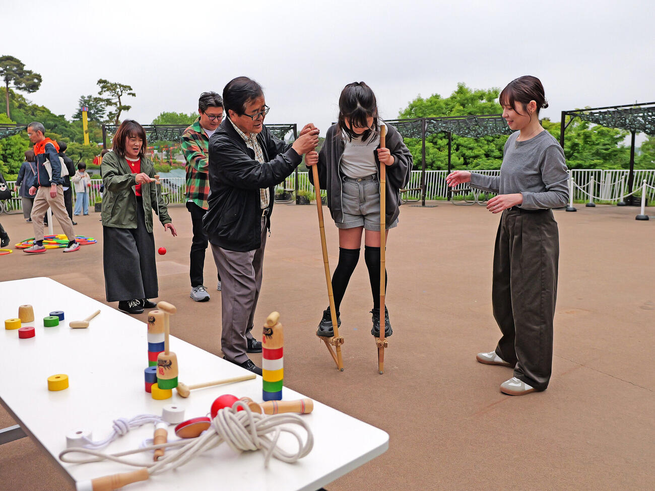 西武園ゆうえんち「昭和お楽しみイベント」で昔懐かしの竹馬などをする来場者たち