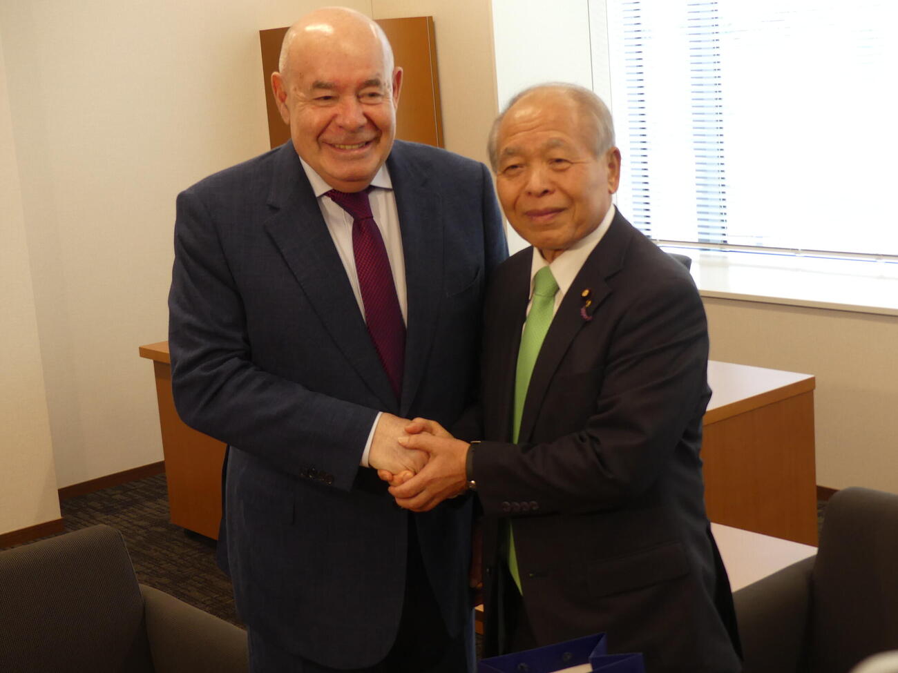 来日しているロシアのシュビトコイ大統領特別代表（左）と握手をかわす自民党の鈴木宗男参院議員（撮影・中山知子）