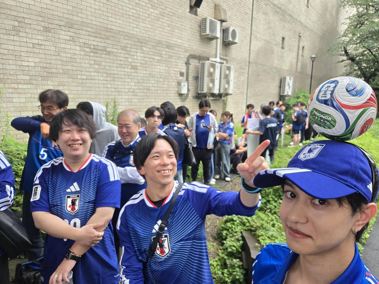 東京タワー隣のスタジオのパブリックビューイングに並ぶサポーターには「鎌田の1ミリ」をモデルにした自作カチューシャも登場