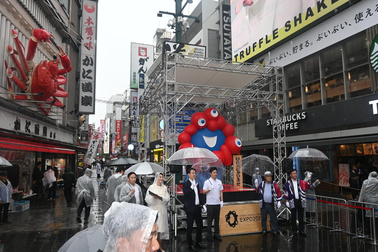 大阪・ミナミの「かに道楽道頓堀本店」前に移設され、除幕式が行われた大阪・関西万博の会場に設置されていた万博の公式キャラクター「ミャクミャク」のモニュメント「いらっしゃい」（撮影・松浦隆司）