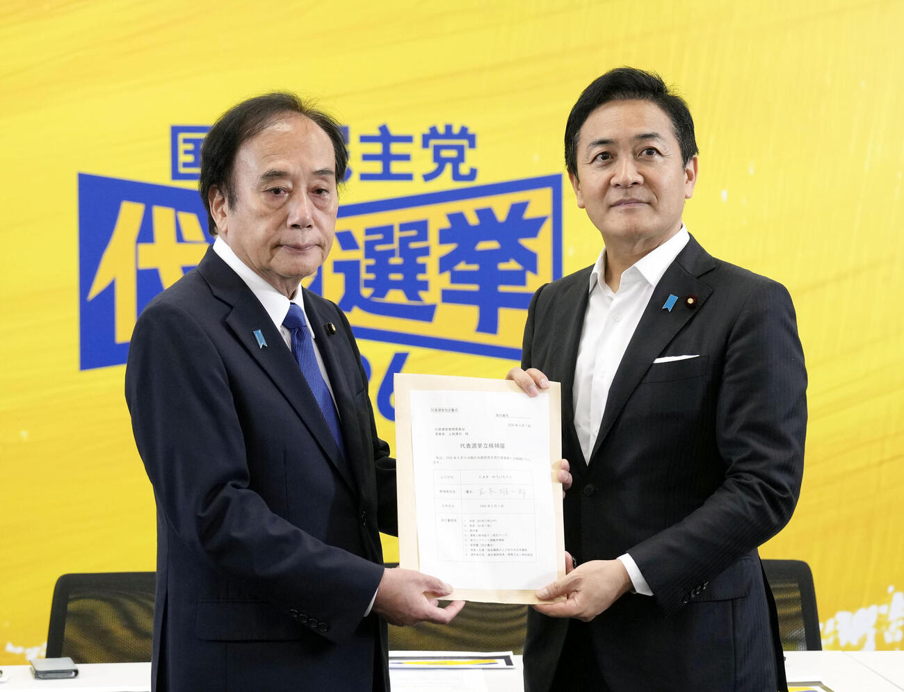 国民民主党の代表選立候補の届け出をする玉木代表。左は上田清司選管委員長＝7日午前、国会（共同）