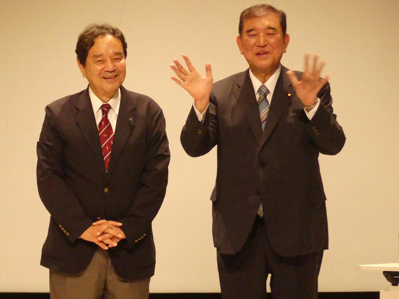 ジャーナリスト鈴木哲夫氏（左）とのトークショーで参加者に手を振って応える石破茂前首相