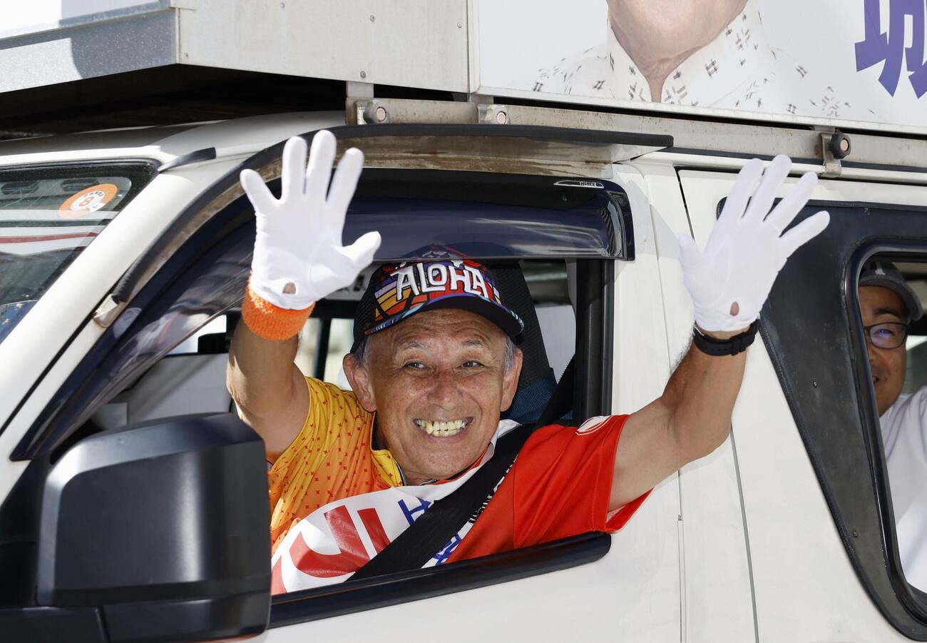 車から有権者らに手を振る玉城デニー氏（共同）
