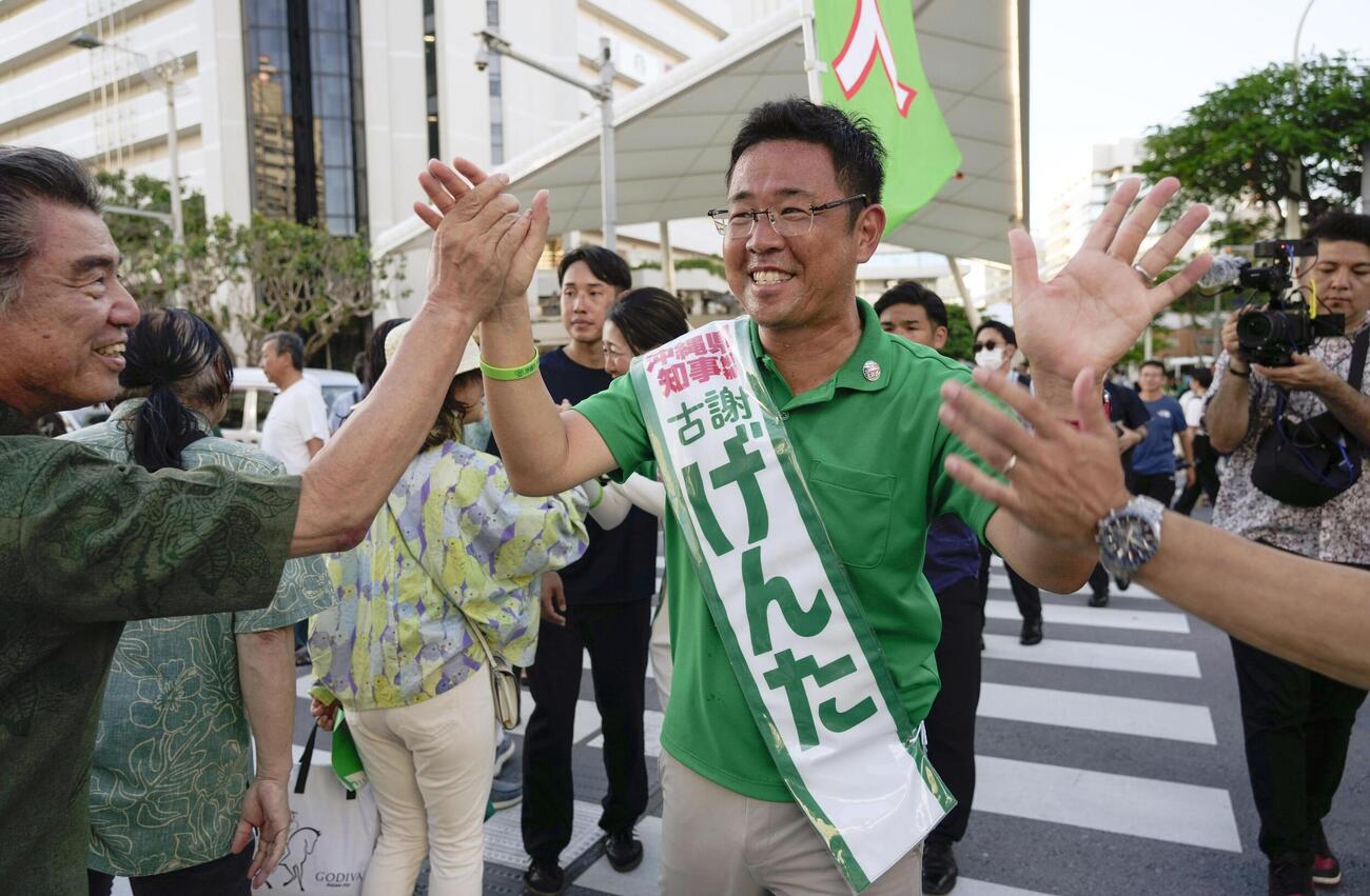 街頭で支持を訴える古謝玄太氏＝12日午後、那覇市(共同)