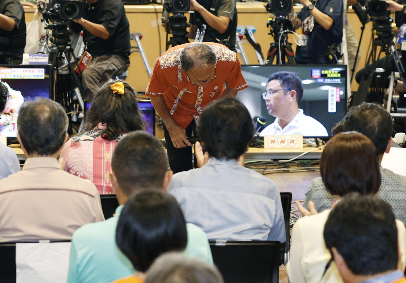 沖縄県知事選で落選が決まり、支援者らに頭を下げる玉城デニー氏（共同）
