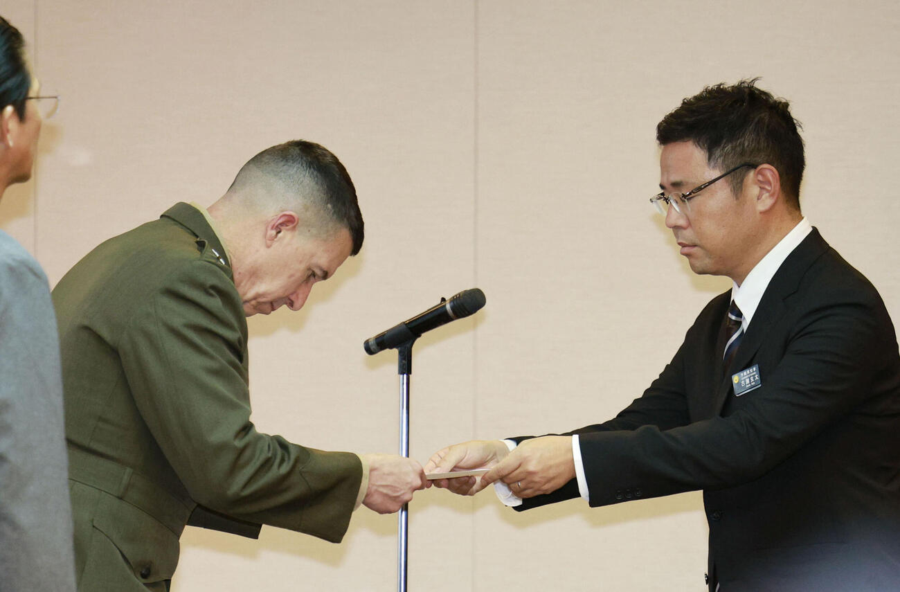 在沖縄米軍の沖縄地域調整官ワトソン中将（左）に抗議文を手渡す沖縄県の古謝玄太知事＝5日午後、沖縄県庁