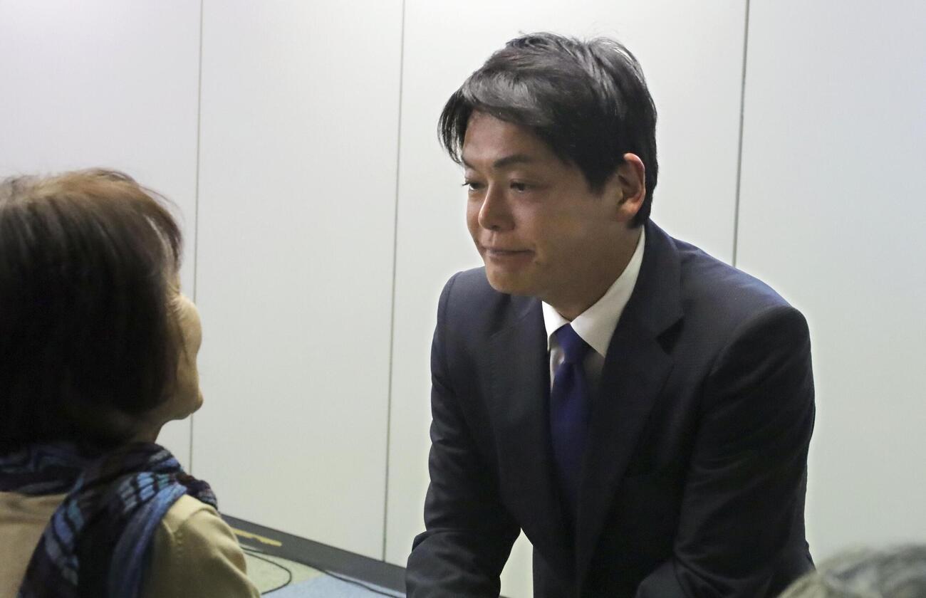 横浜市長選で落選が決まり、支持者と握手を交わす前市長の山中竹春氏＝18日午後、横浜市(共同)