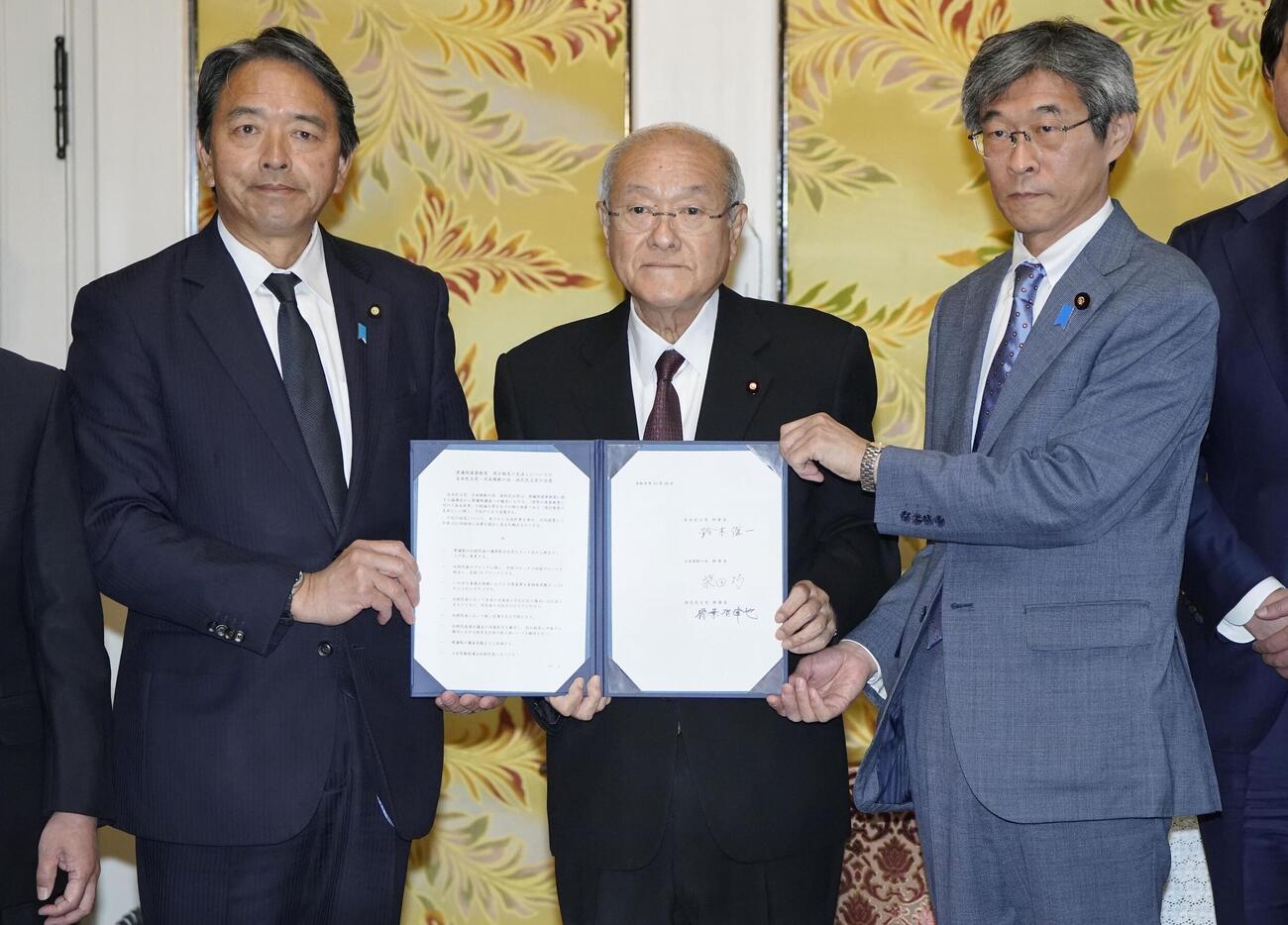 衆院選挙制度改革を巡る比例代表31削減を含む案に正式合意し、撮影に応じる（左から）国民民主党の榛葉幹事長、自民党の鈴木幹事長、日本維新の会の柴田幹事長＝29日午前、国会（共同）