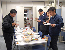 試食を行うケンミン食品の高村一成社長（左）らスタッフ