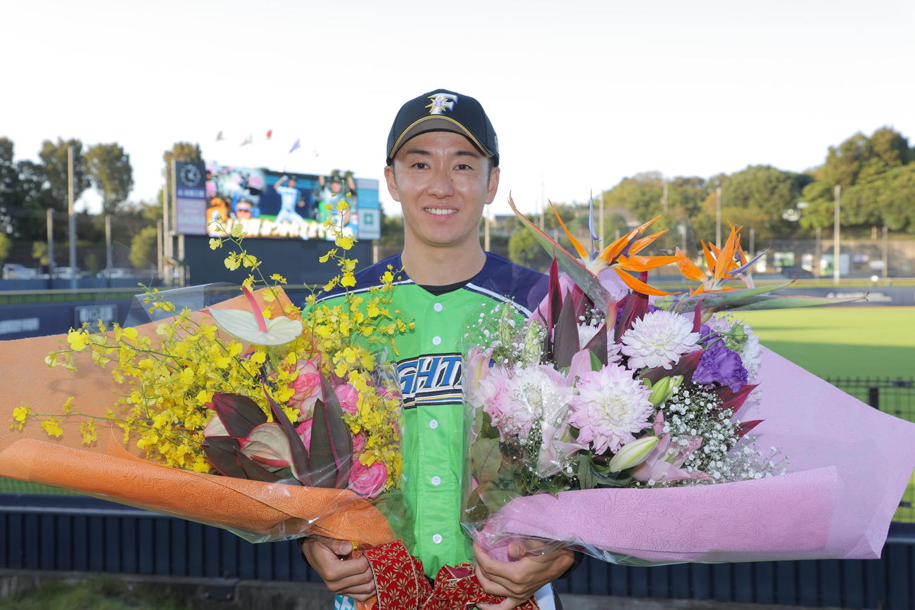 イースタン・リーグの最終登板後、花束を手にする日本ハム斎藤（代表撮影）