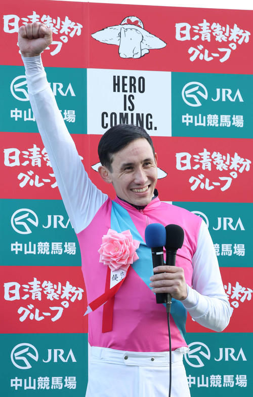 22年12月28日、ホープフルS　優勝インタビューを終えファンの声援にガッツポーズで応えるムルザバエフ騎手