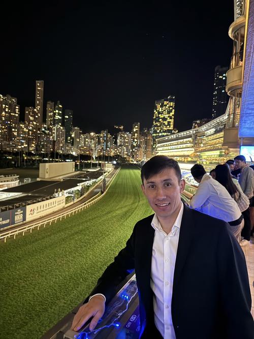 ハッピーバレー競馬場で香港の夜景を背にするムルザバエフ騎手
